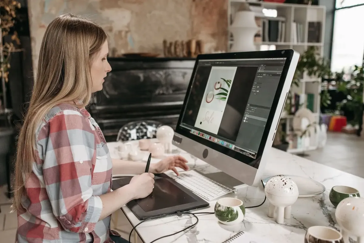 Stock photo: a designer drawing artwork on a tablet, the kind of creator who sells designs on a marketplace