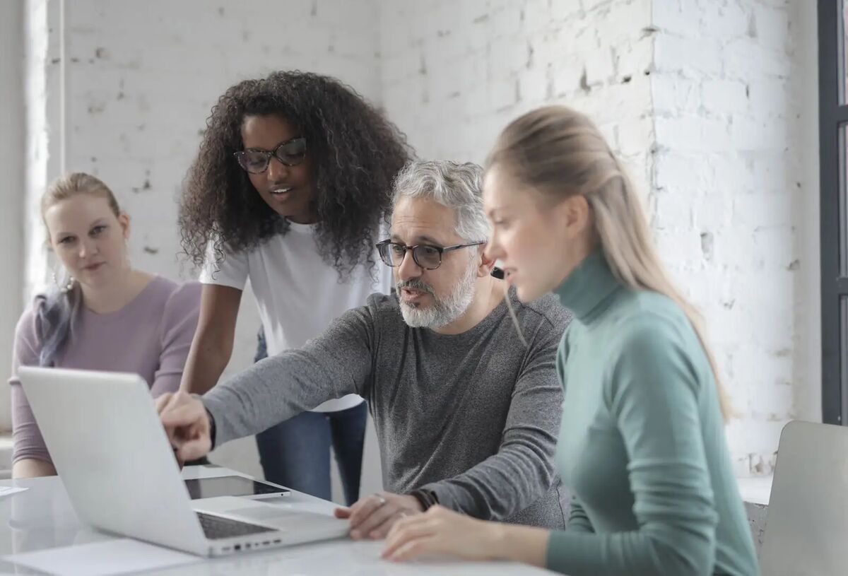 Stock photo: a team reviewing a project together on a laptop, deciding how their print business sells online